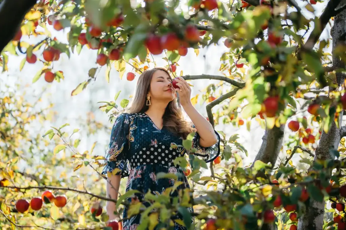 woman smelling flowers in a garden
