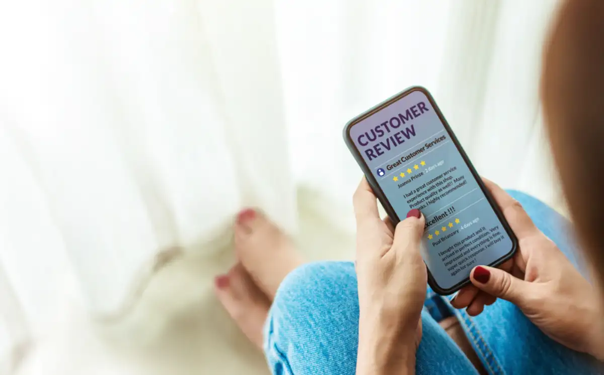 Female sitting in house to Reading Customer Review in Smart Phone