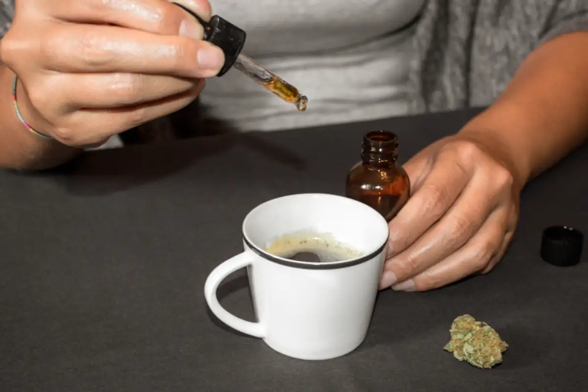 Pouring CBD tincture in a coffee cup