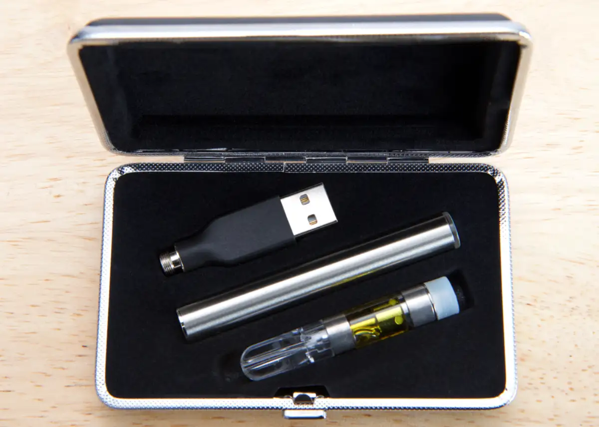 Vaping pen with oil in a velvet lined case that looks like a manicure case