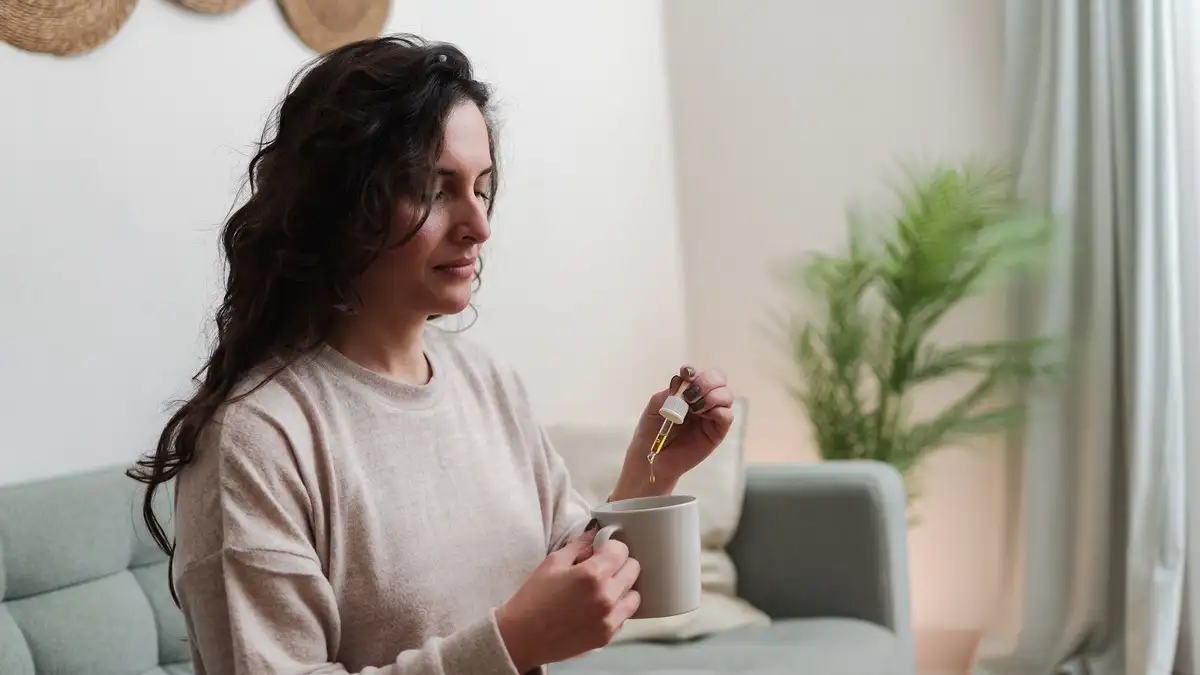 Woman taking cbd oil for anxiety treatment Woman taking cbd oil for anxiety treatment