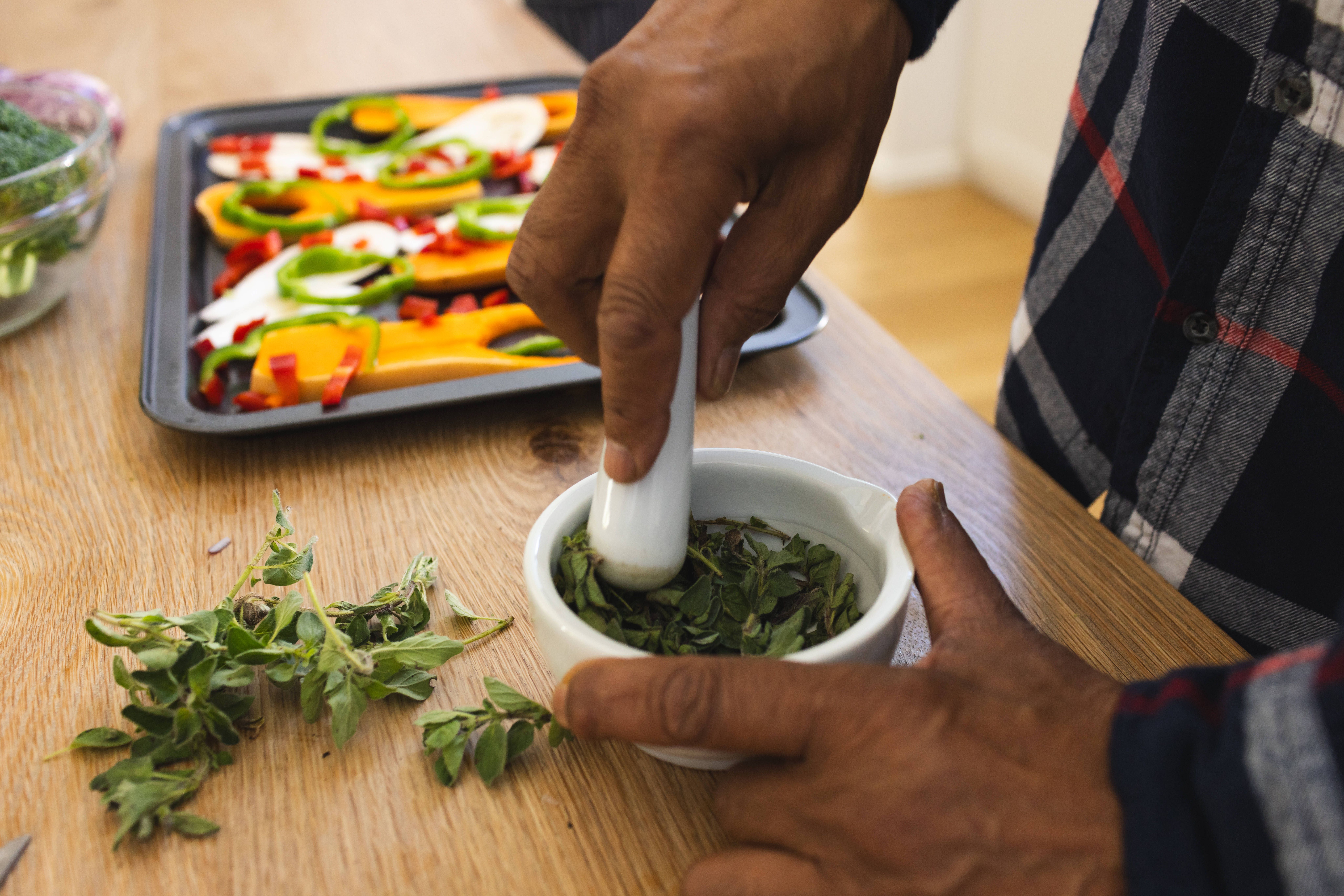 African american senior man preparing healthy meal with vegetables and seasonings in kitchen. Lifestyle, retirement, senior lifestyle, food, cooking and domestic life, unaltered.