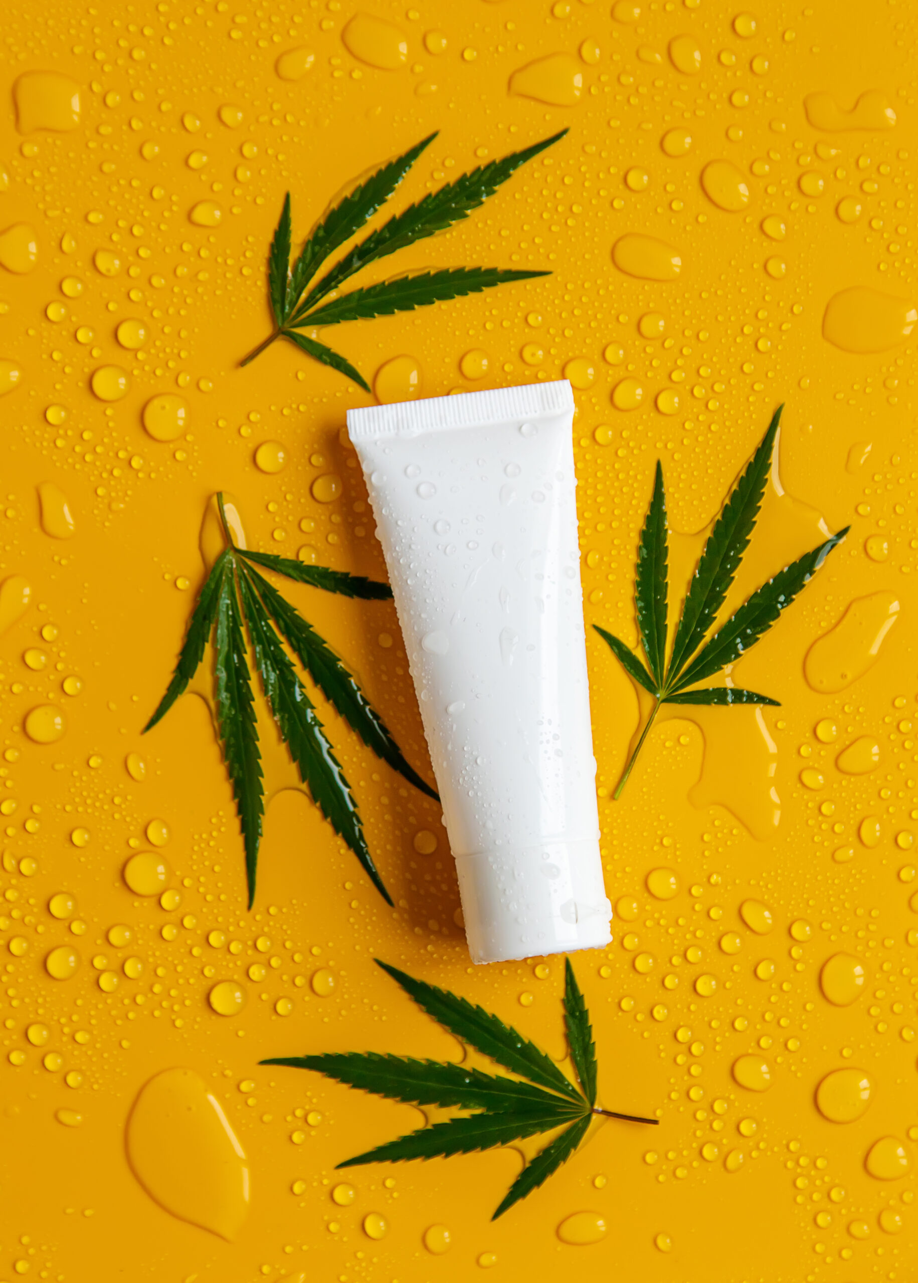 Cosmetics with cannabis extract on a wet background. Selective focus.