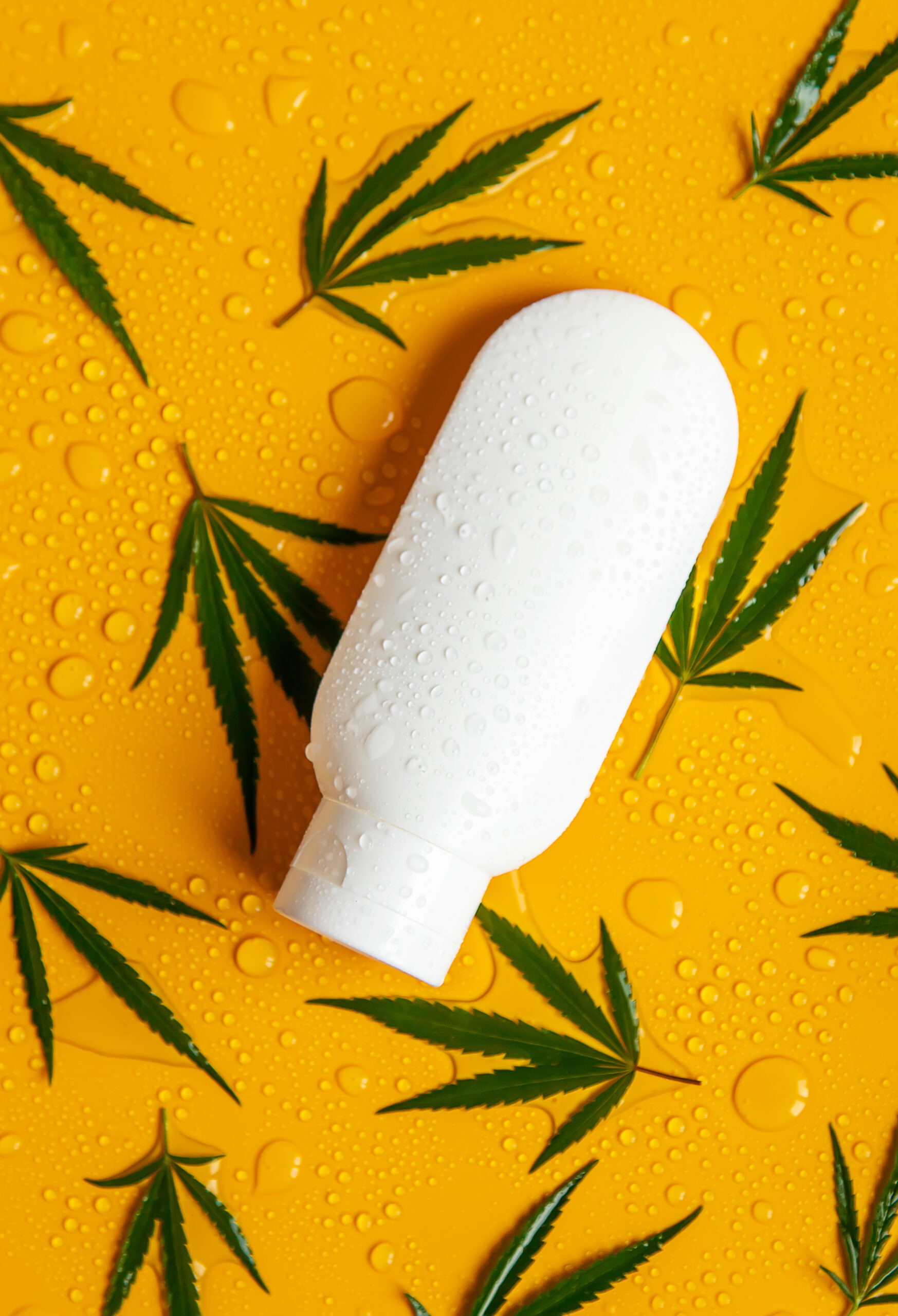 Cosmetics with cannabis extract on a wet background. Selective focus.