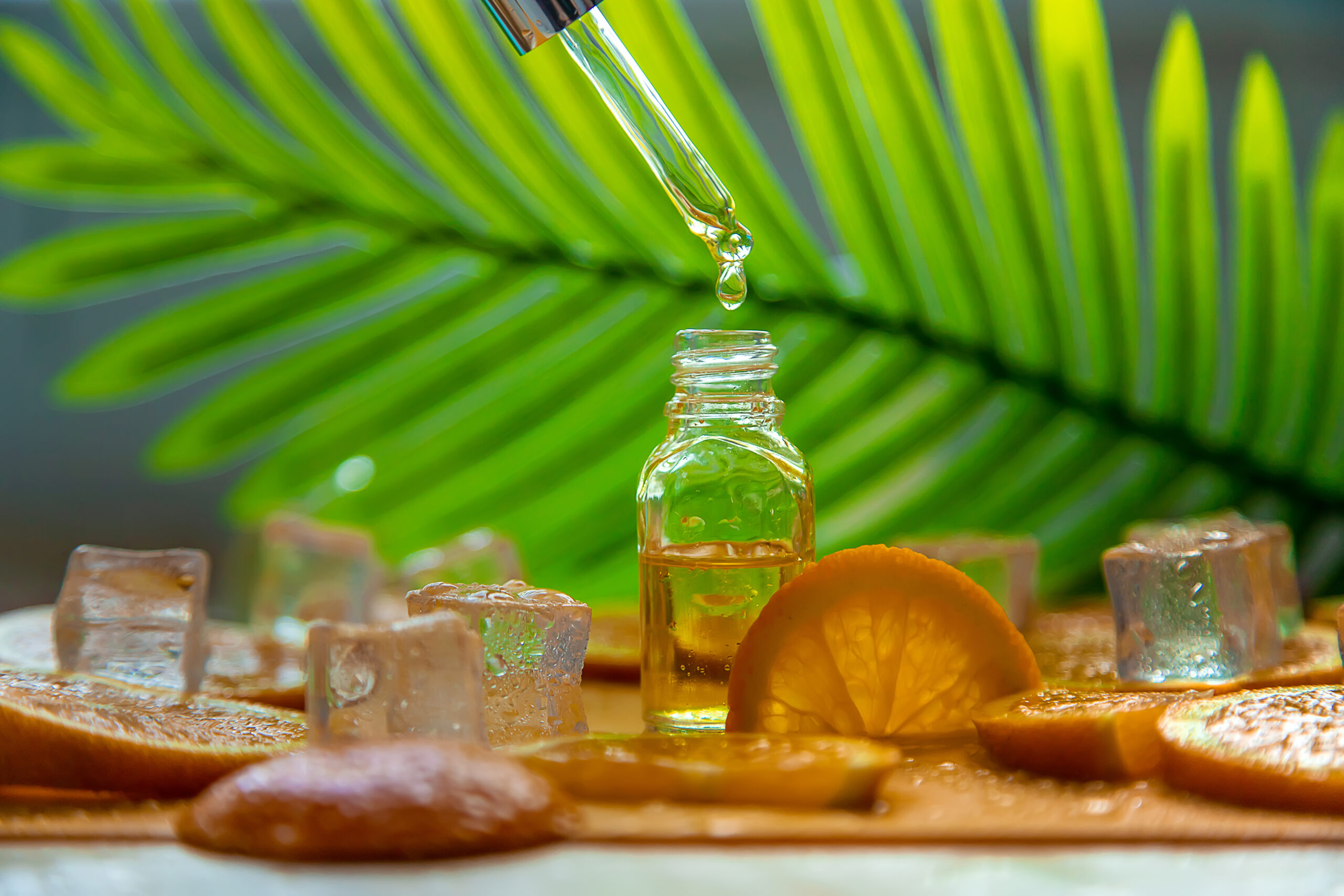 Essential oil of orange on a yellow background. Selective focus.