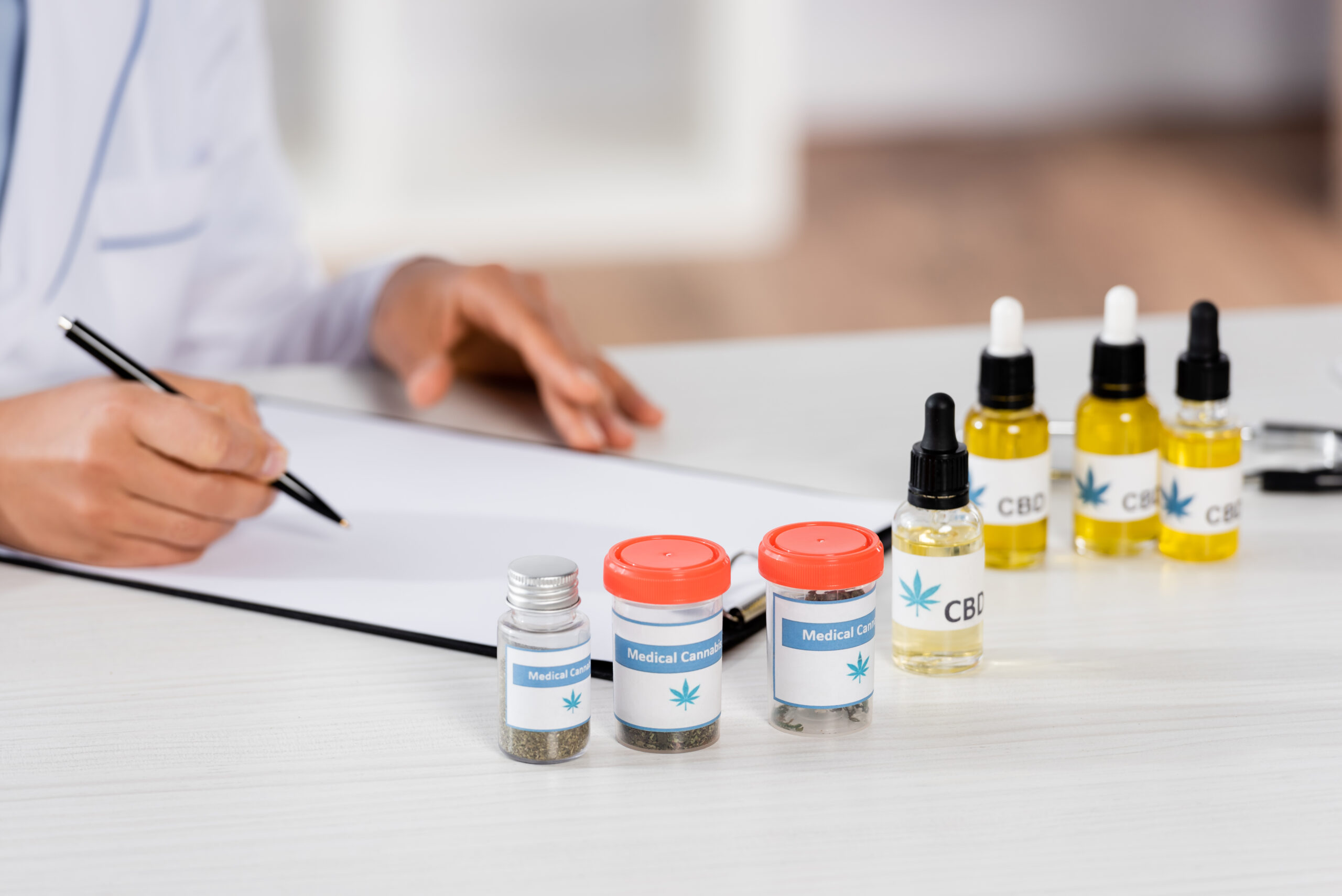 partial view of african american doctor writing prescription on clipboard