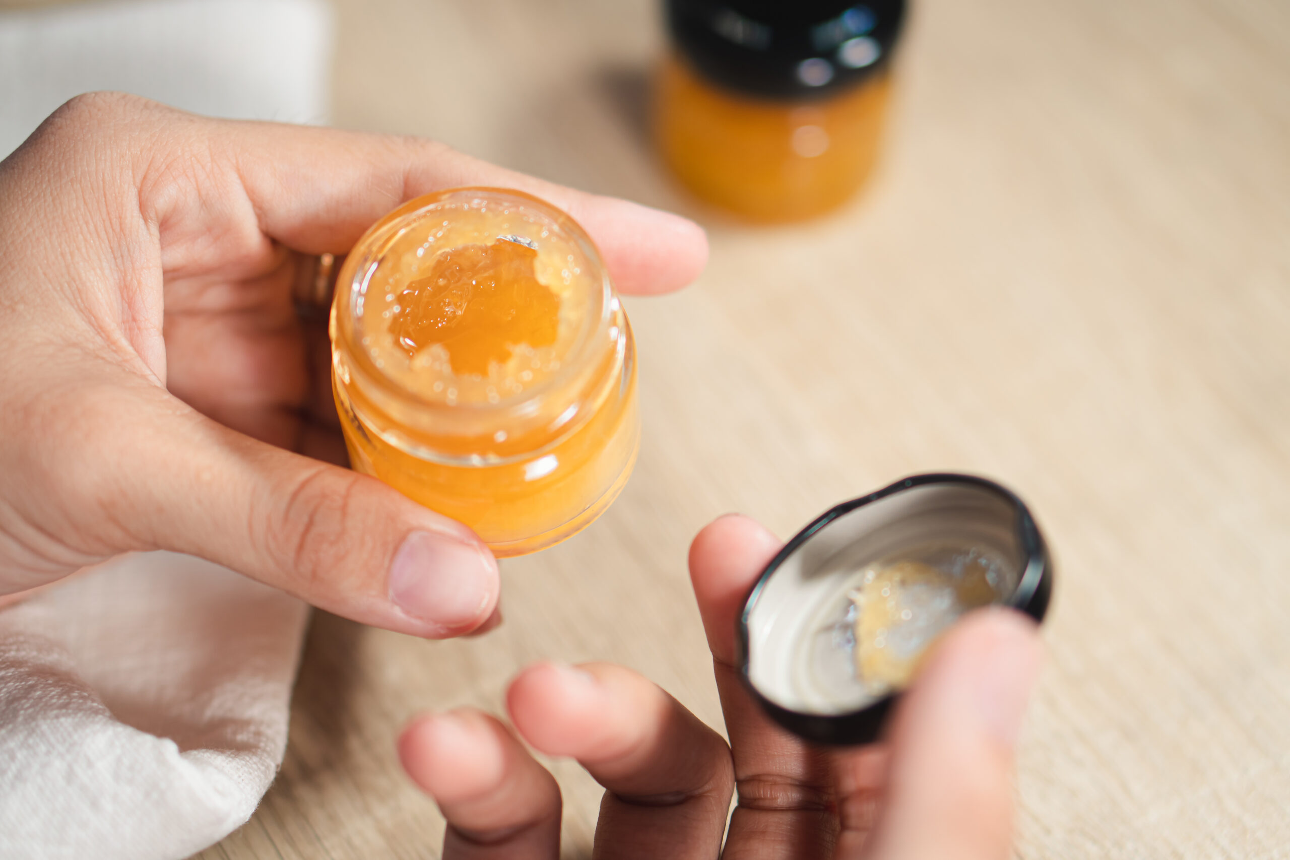 Woman with jar of orange jam, closeup